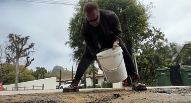 Arnold Schwarzenegger, yoldaki çukuru asfalt dökerek kapattı